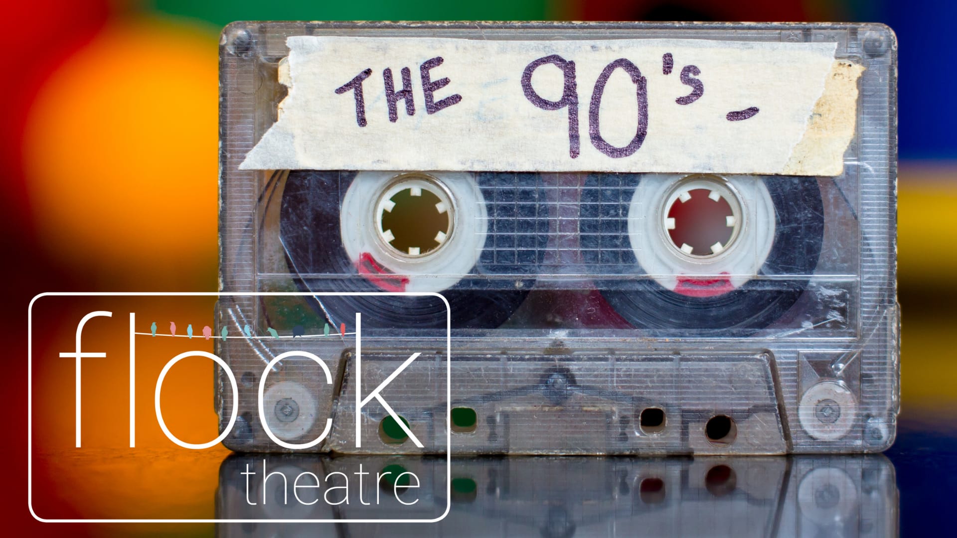A cassette tape with a white sticker where it's written The 90s on a colorful background and the Flock logo.